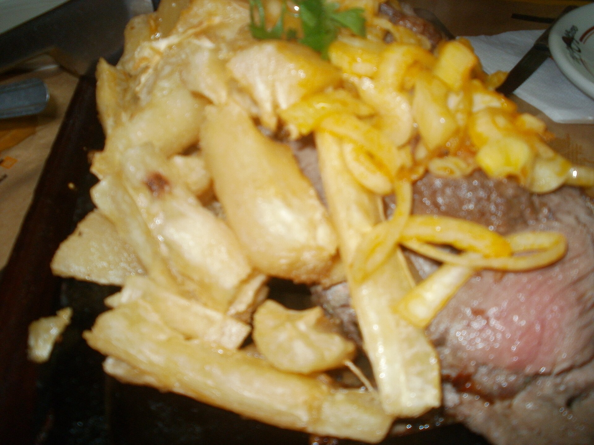 Carne de sol grelhada coberta de macaxeira e cebola dourada