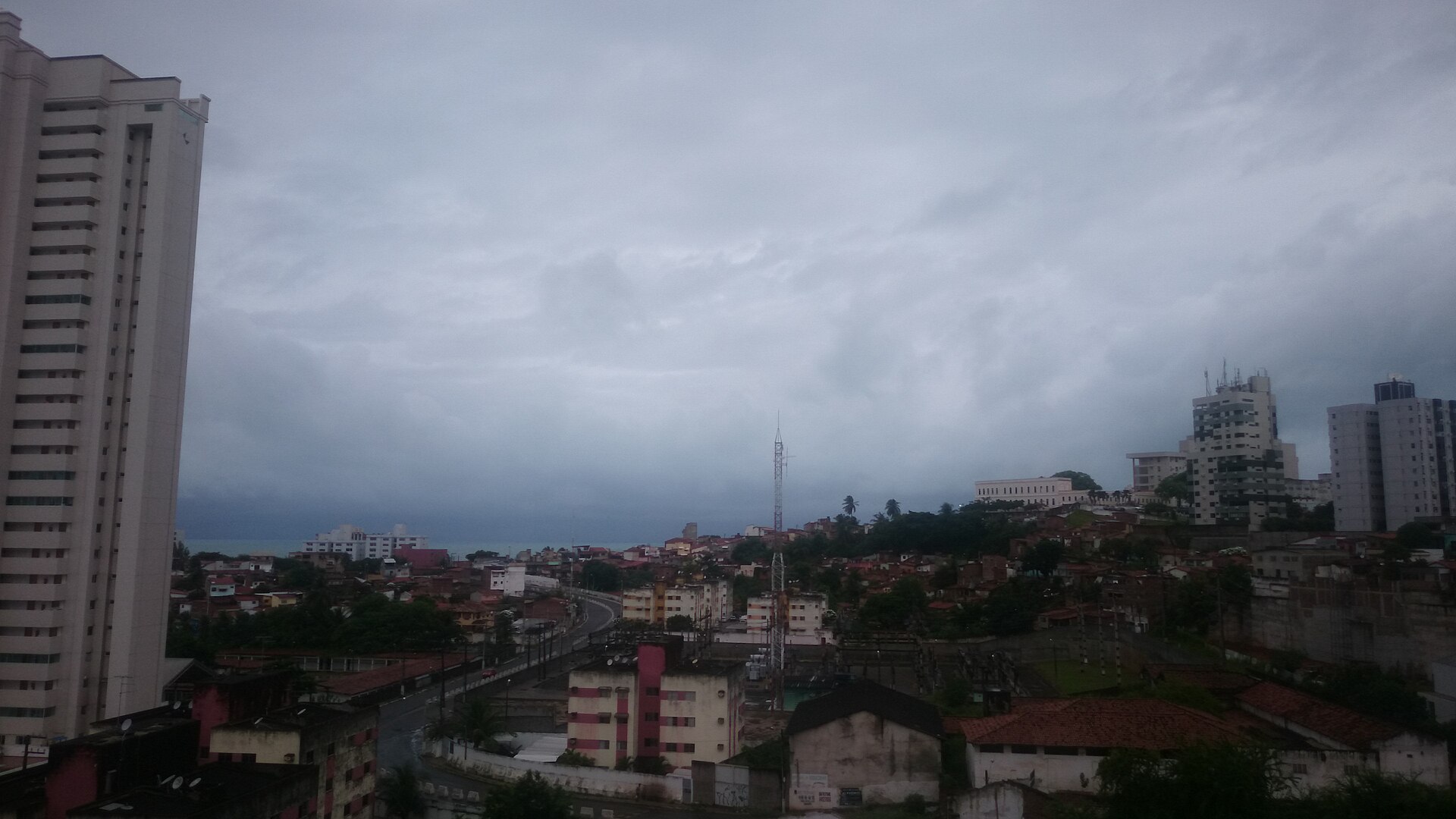 Rain approaching over the buildings, seen from a balcony