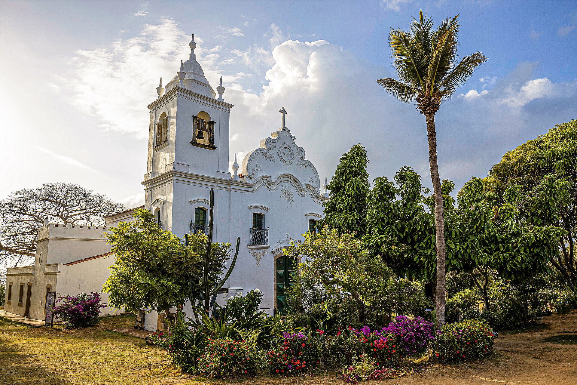 The white Nossa Senhora da Conceição church in Vila Velha, surrounded by garden and palms